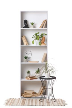 Sehpası, halısı ve dekoru beyaz arka planda olan raf ünitesi.