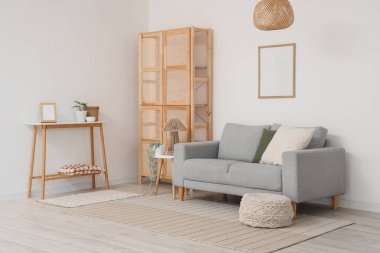 Odanın içi ahşap dolap, kanepe ve masalarla dolu.