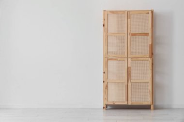 Odanın duvarının yanındaki ahşap dolap.