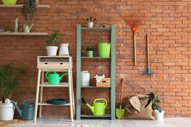 Raf ünitesi, masa ve bahçe aletleri ile atölyenin içi