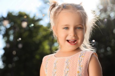 Parkta sabun köpüğü olan şirin küçük kız, yakın plan.