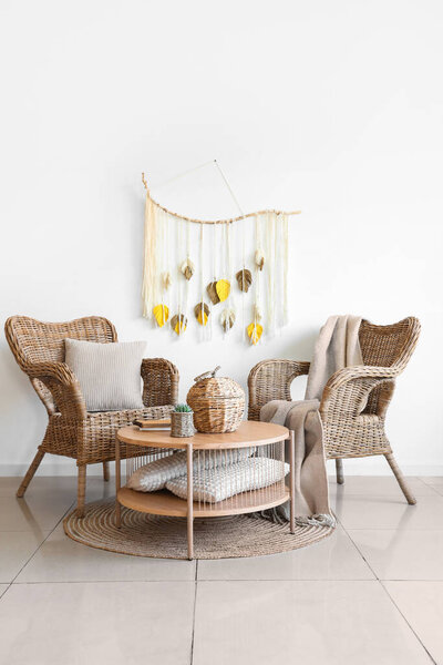 Interior of living room with rattan armchairs and wicker basket on coffee table