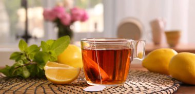 Bir fincan sıcak aromatik çay, limon ve taze nane. 