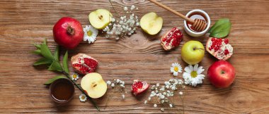 Ahşap zemin üzerinde taze meyve, çiçek ve baldan yapılmış çerçeve. Rosh hashanah (Yahudi Yeni Yılı) kutlaması