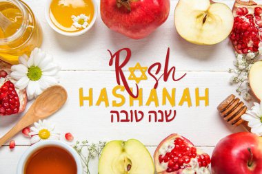 Meyve, çiçek ve baldan yapılmış çerçeve beyaz ahşap arka planda, yakın plan. Rosh hashanah (Yahudi Yeni Yılı) kutlaması