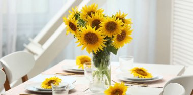 Yemek odasında ayçiçekli masa ayarları.