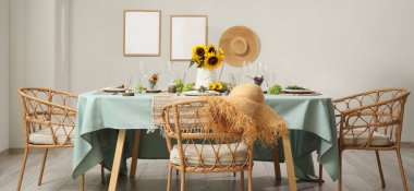 Güzel ayçiçekleri, çiçek dekoru ve mumlarla servis edilen yemek masası.