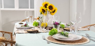 Güzel ayçiçekleri ve çiçeklerle servis edilen yemek masası.