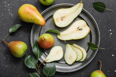 Siyah masada olgun armutlarla kaplanmış, yakın plan.