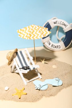 Renkli arka planda mini şemsiyeli, şezlonglu ve plaj aksesuarlı yaratıcı yaz kompozisyonu