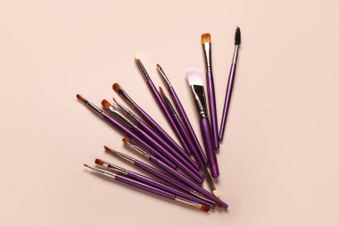 Pembe arkaplanda makyaj fırçaları