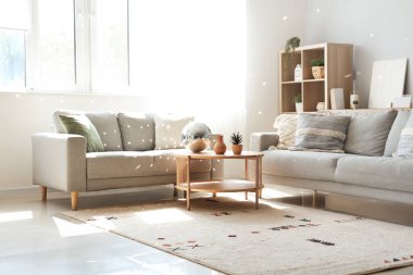 Kahve masasında gri kanepeler ve disko topu olan modern oturma odasının içinde.