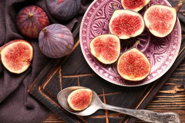 Ahşap zemin üzerinde taze taze incir yarımları ile tabak