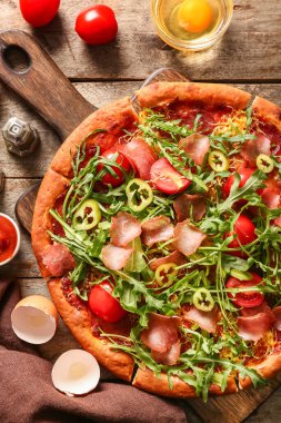 Tahta arka planda domatesli ve roka aromalı lezzetli pizzalar.