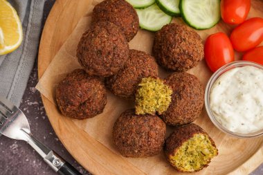 Nefis falafel köfteli ahşap tabak, soslu ve sebzeli grunge arka planda, yakın plan