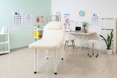 İş yeri ve kanepesi olan göz doktorunun ofisi.