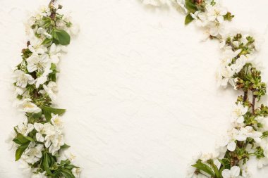 Beyaz arkaplanda çiçek açan dallardan oluşan bir çerçeve