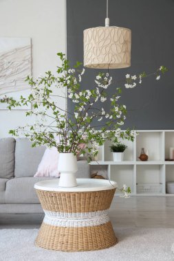 Odadaki sehpanın üzerinde çiçek açan bir vazo.