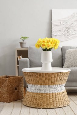 Oturma odasındaki sehpanın üzerinde güzel narsist çiçekleri olan vazo.