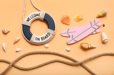 Yaşam halkası, sörf tahtaları, halat ve bej arka planda deniz kabukları. Yaz konsepti