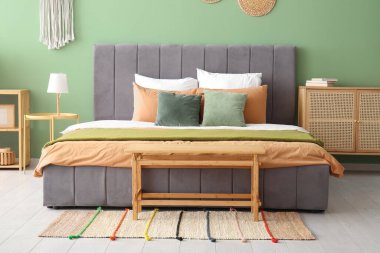 Şık bir yatak odasında rahat bir yatak, lamba ve komodin.