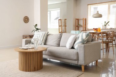 Gri kanepesi ve masası olan şık bir mutfak.