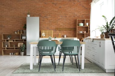 Modern mutfak, yemek masası ve buzdolabı.