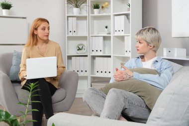 Ofiste genç bir kızla konuşan kadın psikolog.