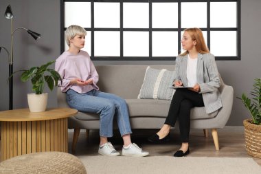 Ofisteki koltukta oturan üzgün genç kız.