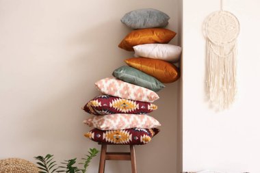 Şık bir odada koltukta yumuşak yastık yığını.