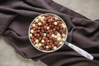 Gri arka planda sağlıklı mısır topları olan bir kase.