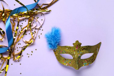 Leylak arka planında tüylü ve yılanımsı güzel altın karnaval maskesi