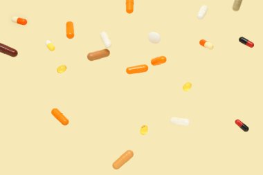 Sarı arka planda renkli haplar.