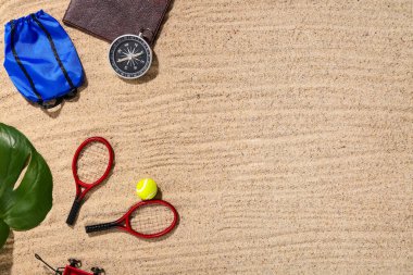 Pasaport, pusula ve kumdaki oyuncaklar.