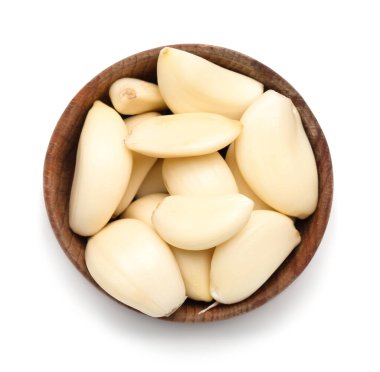 Beyaz arka planda taze sarımsak karanfilleri olan ahşap bir kase.