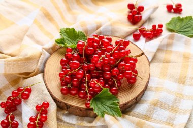 Taze kırmızı üzümlü ahşap tahta ve beyaz arka planda yapraklar, yakın plan.