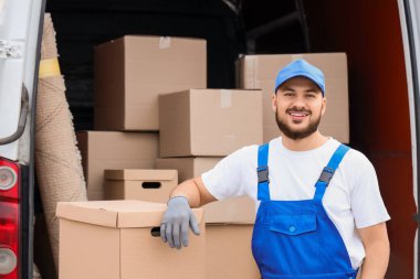 Erkek nakliyeci sokakta kutu boşaltıyor.