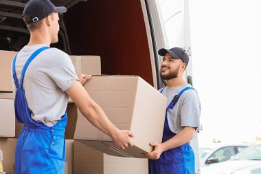 Erkek nakliyeciler dışarıdan kutuları boşaltıyor.