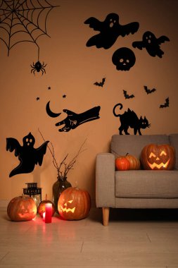 İçinde kanepe ve Cadılar Bayramı balkabağı olan karanlık bir oturma odası.