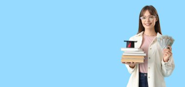 Elinde kitap, harç tahtası ve mavi arka planda mesaj için yeri olan bir kız öğrenci. Eğitim tasarruf kavramı