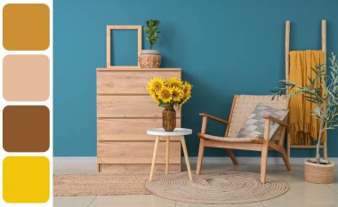 Ahşap klozet, koltuk ve mavi duvarın yanındaki masada güzel ayçiçekleri olan bir oda. Farklı renk desenleri