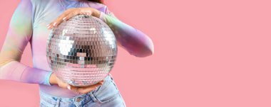 Pembe arka planda disko topu olan şık bir kadın ve metin için yeri var.