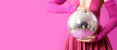 Eflatun arkaplan üzerinde disko topu olan genç bir kadın.