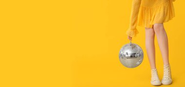 Sarı arka planda disko topu olan genç bir kadın ve mesaj için yeri var.