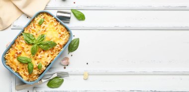 Beyaz ahşap arka planda peynirli lezzetli makarna pişirmek.