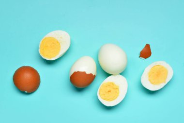 Lezzetli kaynamış yumurta ve mavi arka planda kabuklar.