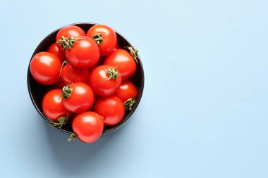 Mavi arka planda taze vişne domatesli kase