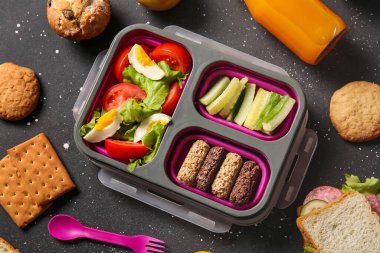 Lezzetli yemekler ve siyah arka planda bir şişe meyve suyu.