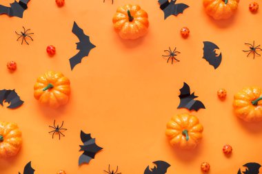 Kabaklardan, kağıt yarasalardan ve turuncu arka planda örümceklerden yapılmış çerçeve. Cadılar Bayramı konsepti