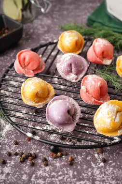 Renkli çiğ hamur köfteleri, biberli ve dereotlu koyu arkaplan.